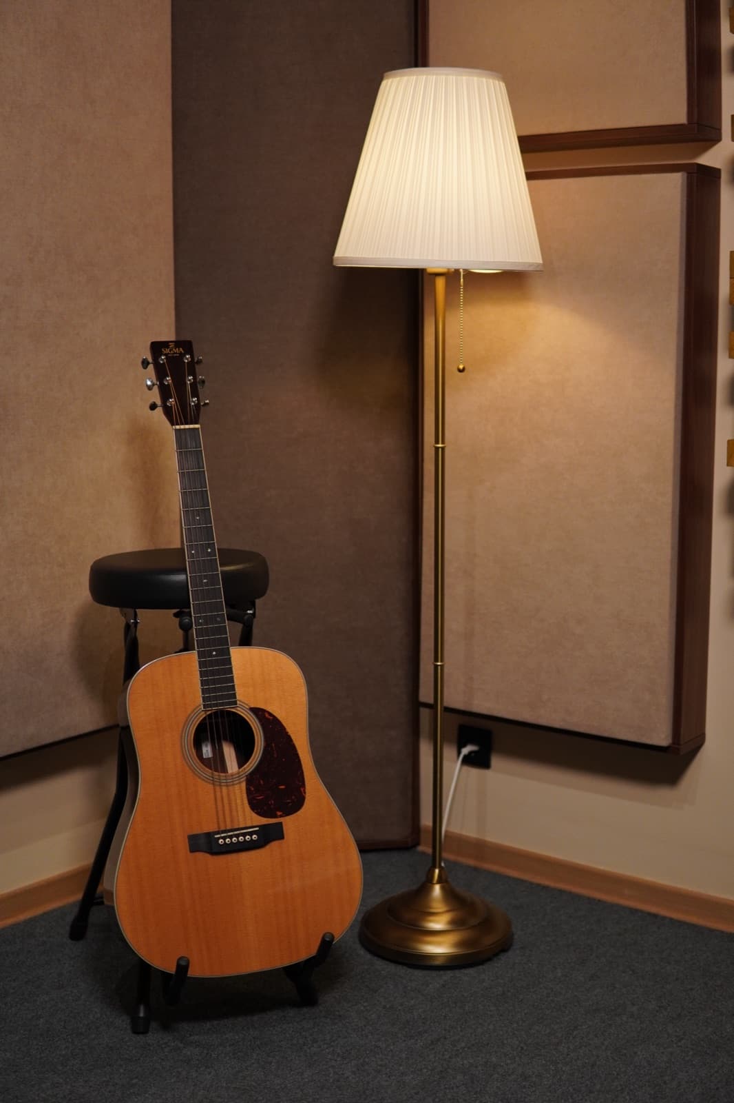 Akustična gitara na zidu pored lampe u sobi za snimanje Studio4